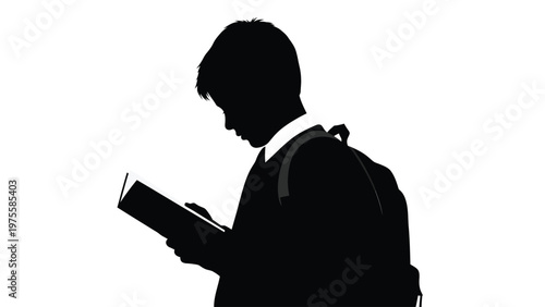 Silhouette of a young student boy standing and reading a book with a backpack on his shoulders
