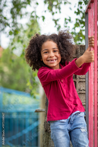 beautufil girl playing outdoors in the playground, sweetheart showing heart made with hands and sending love 