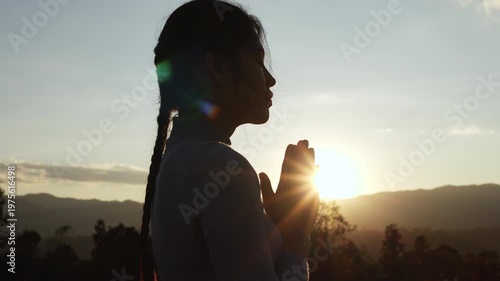  silhouette of a woman open palm prayer on mountain top.