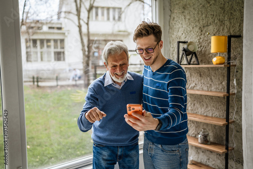 Konstfotografi Generational men enjoying video call on smart phone at home