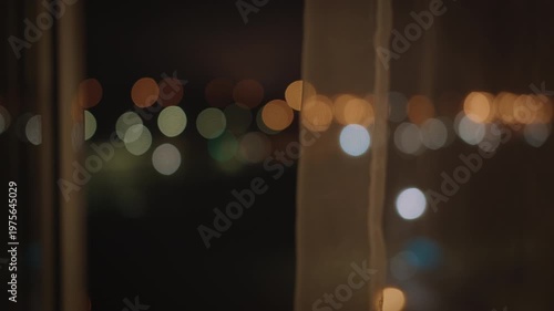 Soft blurred night city lights with transparent curtain texture. Minimal abstract composition, calm evening mood, urban tranquility, perfect background for design and cinematic visuals.