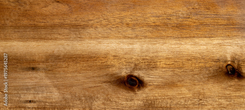 Natural light brown wooden board surface with organic grain patterns and dark knots showing detailed timber texture