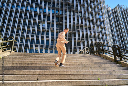 Ambitious man in business attire climbing stairs outdoors
