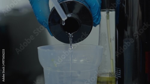 In a beauty salon, a hairdresser pours a special hair care liquid