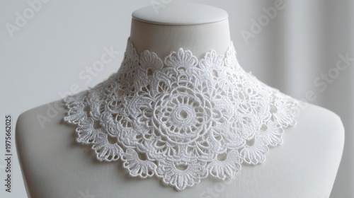 Close-up of an Intricate White Lace Collar Displayed on a Mannequin Neck Form Against a Softly Blurred Light Gray Background Focusing on Delicate Crochet Patterns and Edging Details