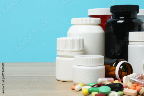 Photos Medical bottles, syringe and pills, on wooden table and blue background