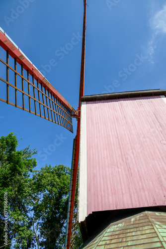 Low angle view of red windmill and pink building