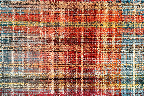 Colorful textured abstract rug seamless pattern with rustic red orange and yellow woven threads creating a vintage style