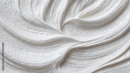 Close up texture of thick pearlescent white cosmetic cream with subtle glitter swirls and flowing lines on a bright background