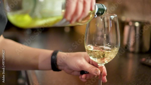 A Bartender Pours white Wine Into A Glass