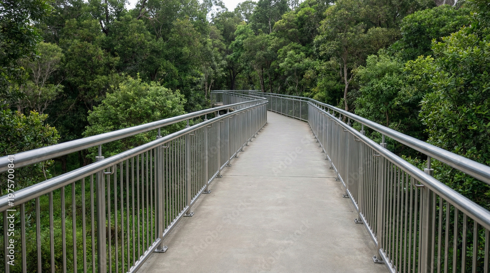 Fototapeta premium Elevated walking trail with metal railing through lush greenery 