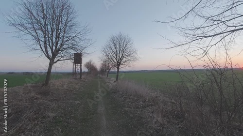 Hunting stand in nature during a peaceful morning. Wooden hunting tower surrounded by countryside landscape with soft sunrise light, perfect for wildlife, outdoor, and rural background concepts.