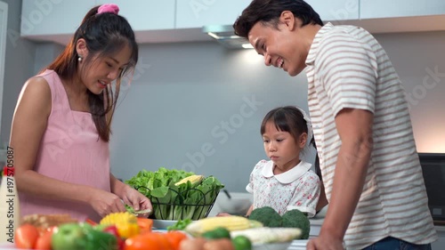 Pregnant woman and husband with little daughter cooking together