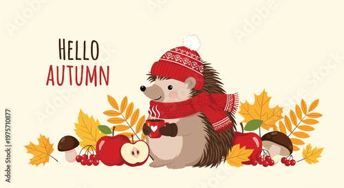 Adorable hedgehog wearing a red winter hat and scarf holding a cup of tea among autumn leaves and mushrooms for seasonal cards.