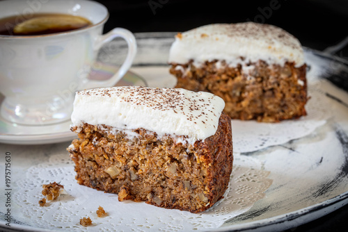 Carrot cake with almond flour and walnuts, topped with whipped cream. Gluten-free.