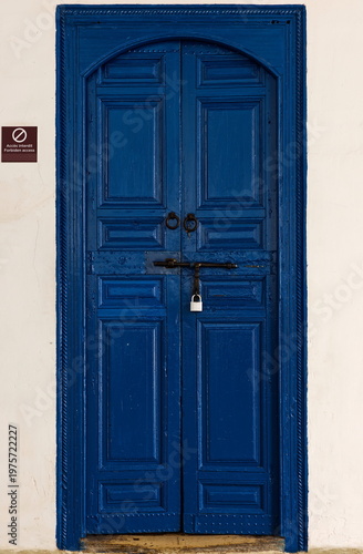 Closed, blue wooden door in the wall between the doorway and the minor courtyard of the luxurious, Moorish style Bahia Palace. Marrakesh-Morocco-261
