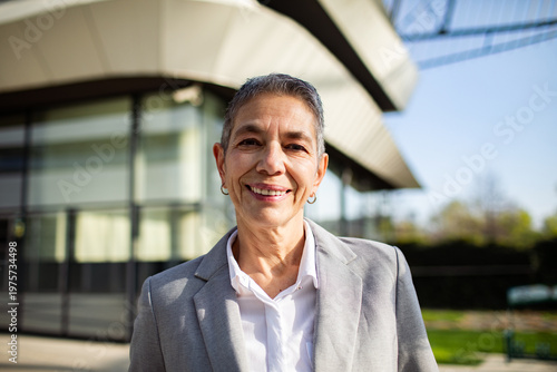Confident senior businesswoman smiling outside office