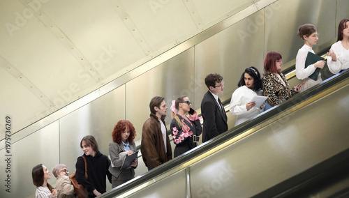 People standing on escalator in subway station forming line during daily commute. Concept of routine behavior, urban mobility, passive movement, time management, structured public transport system.