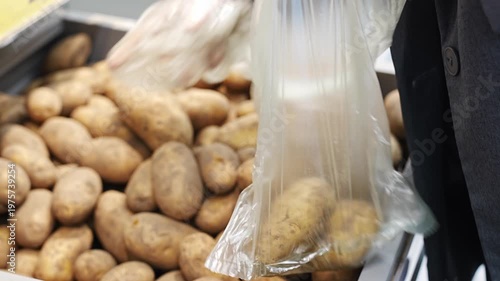 Choosing potatoes in a store for budget-friendly shopping