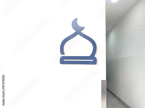 Silhouette mosque sign on the white wall beside the corridor entrance hall, copy space for text 