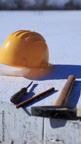 Construction tools and helmet on a cement foundation with iron rebar.