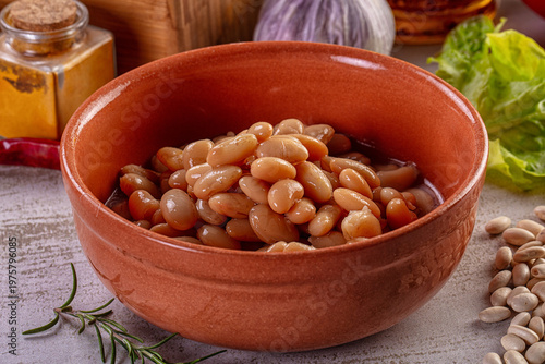 Fotografi Cooked white beans in a terracotta bowl with fresh vegetables and spices