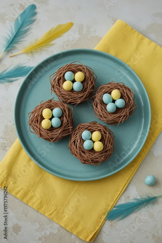 Cute edible nests with colorful eggs on a blue plate at home