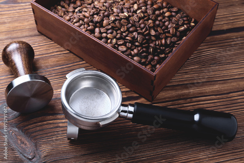 Foto a cup of coffee, coffee beans, a coffee horn and a tamper on a wooden background