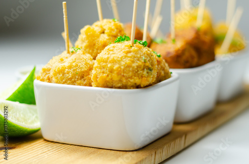 Golden meatballs on wooden skewers, neatly arranged