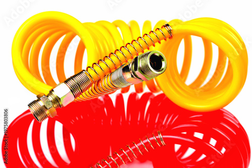 pneumatic hose of a truck for supplying compressed air from a tractor to a trailer, car accessories, car parts, yellow and red, detail  white background  selective focus