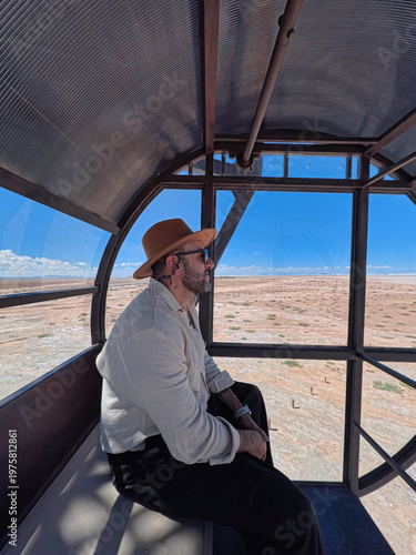 Man in Hat Looking Out from a Modern Cabin Over the Bolivian Altiplano Near Uyuni