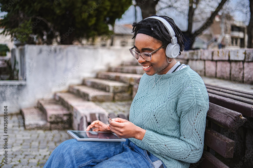 Obraz premium Young black woman online shopping using digital tablet and credit card