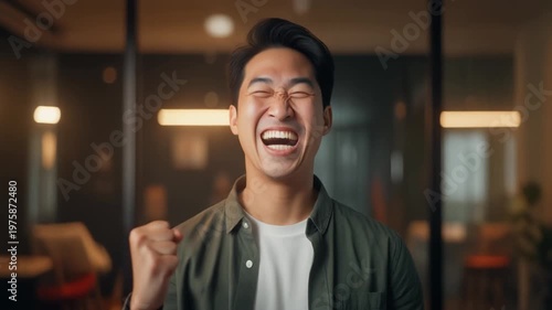 Cinematic footage of a person celebrating a small achievement, pumping fist or smiling broadly, natural indoor or office environment, warm lighting highlighting emotion, ultra realistic, 4K
