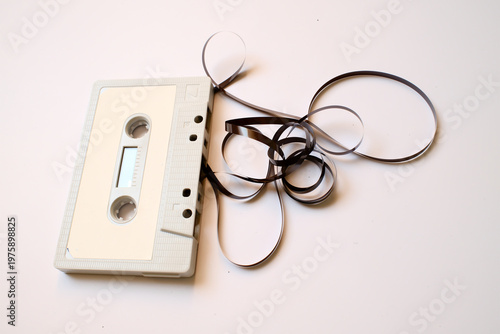 Unraveled vintage white cassette tape on white background