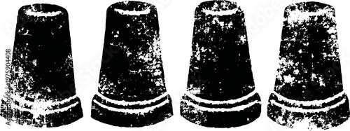 Four vintage metal thimbles lined up in a row, textured close up black and white image