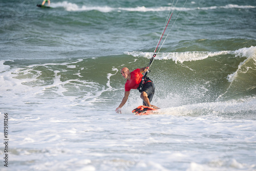 extreme kitesurfer riding a kite on the waves in the sea