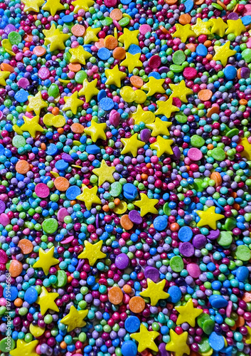 Bright colorful sugar sprinkles with star shapes and candy confetti forming a vibrant seamless background. Perfect festive texture for party, baking, and kids design.