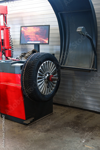 Tire balancing machine performing service on a car wheel with winter tire