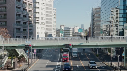 Tokyo Scene  :  Pedestrian Bridge and Traffic Lights with Arrow Signals at the Arterial Junction Surrounded by Towering Skyscrapers Under Clear Skies  |  Shibuya, Tokyo, Japan