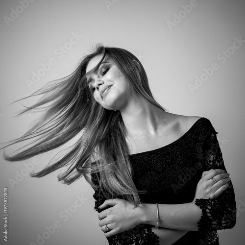 Stylish monochrome portrait woman with dynamic hair movement and soft light
