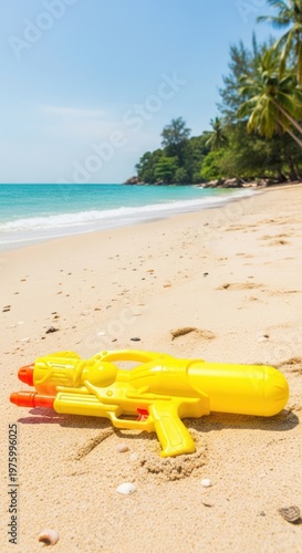 Yellow Water Gun on Sandy Beach with Ocean and Palm Trees