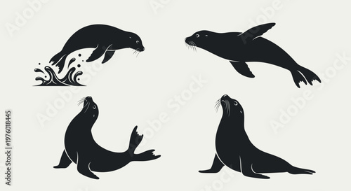 Set of four black silhouettes of seals in various poses.