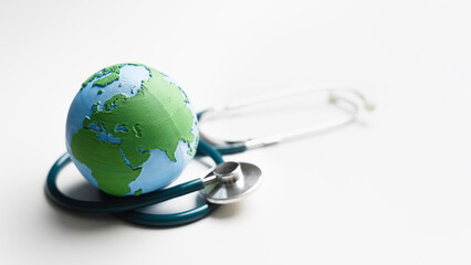 Global health care Awareness, world health monitoring, planet ecology medical checkup Concept. Medical stethoscope and Earth on white background for Sustainable Environment and World Health Day