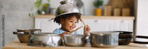 Preschooler playing drums with kitchenware at countertop