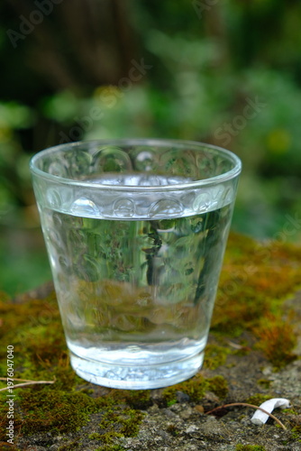glass cup filled with mineral water on the stone table