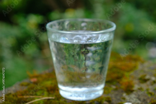 glass cup filled with mineral water on the stone table
