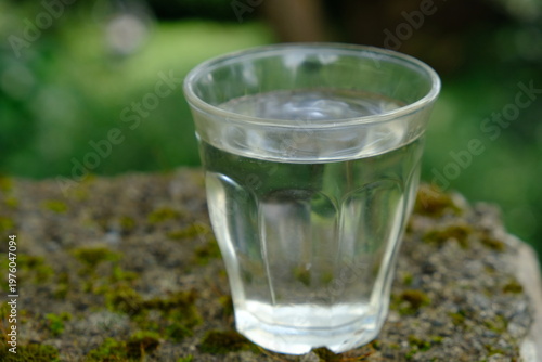 glass cup filled with mineral water on the stone table