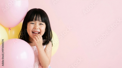 Happy Japanese girl in party dress laughing with pastel balloons, copy space on clean background