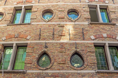 Facade of an old brick Italian house with glass stained glass windows. Horizontally. 