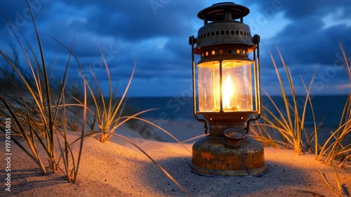 Lit lantern on sand dunes at night.